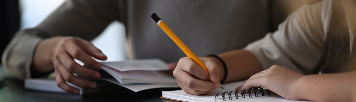 Female private tutor helping young student doing homework . Tuto