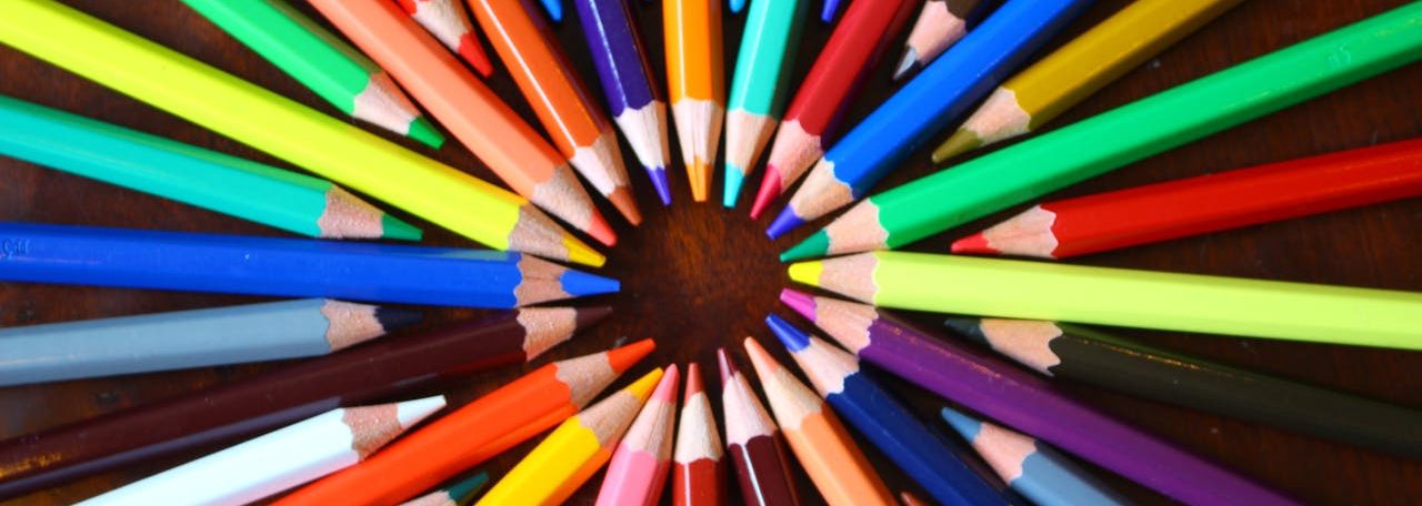 Assorted-color Pencils Forming Circle on Brown Surface